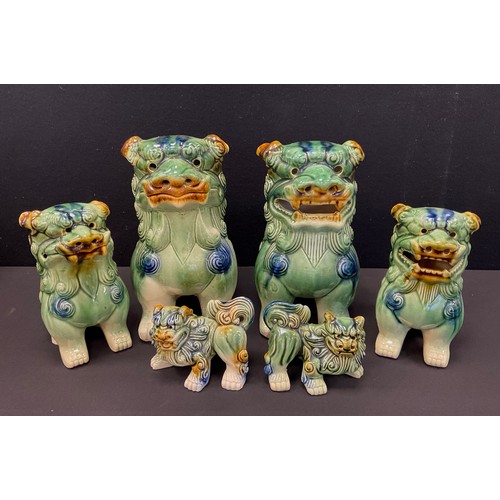 96 - Three graduated pairs of Chinese Temple Lions, green, blue, and ochre coloured glaze, the largest st... 