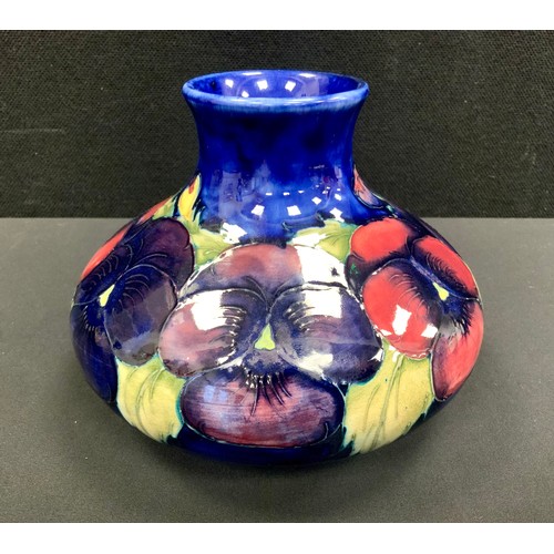 128 - A Moorcroft pottery compressed ovoid vase, tube lined in the Pansy pattern, blue ground, 12.5cm high... 