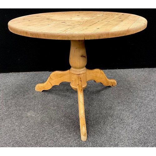 208 - A pine tilt-top dining table, 77cm high x 104cm diameter.