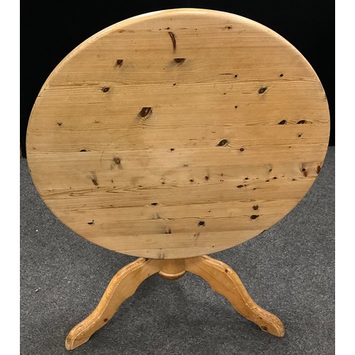 208 - A pine tilt-top dining table, 77cm high x 104cm diameter.