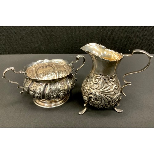322 - A Victorian silver sugar bowl and similar cream jug, both repousse decorated with flowers, twin hand... 