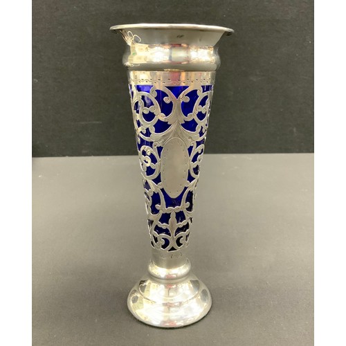 329 - An Edwardian silver and blue glass trumpet form bud vase, pierced scrolling body, stepped foot, 18cm... 