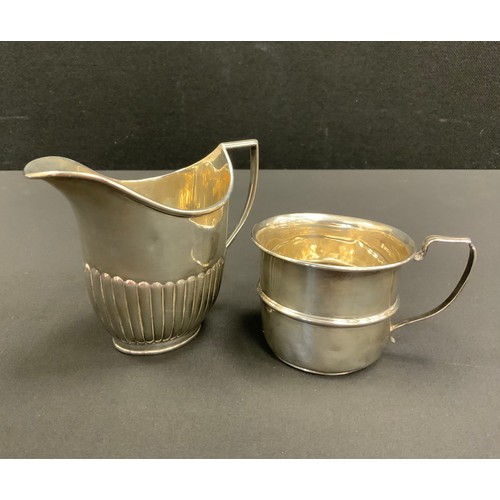330 - An Edwardian silver gadrooned milk jug, William Hutton & Sons Ltd, London 1903;  a Christening cup, ... 
