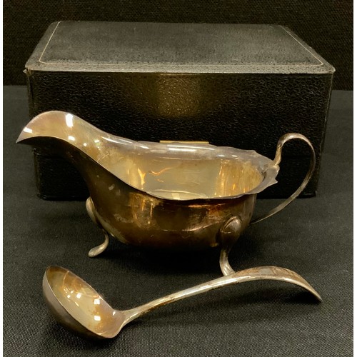 338 - A Elizabeth II silver sauce boat with spoon, cased, Sheffield, 1957, 131.2 grams