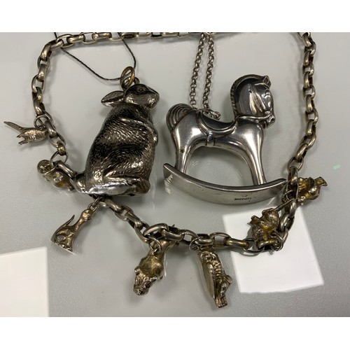 422 - A Topazio silver coloured metal Rocking Horse pendant necklace, signed;  gilt silver charms necklace... 