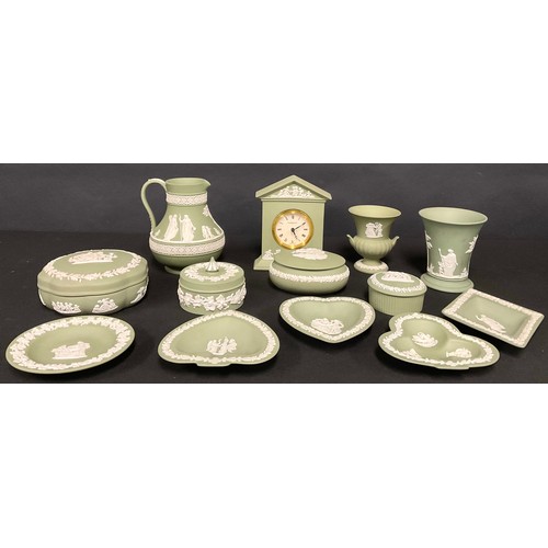 72 - A quantity of Wedgwood green Jasperware, including pill boxes, clock, trumpet vase, urn, jug, trinke... 