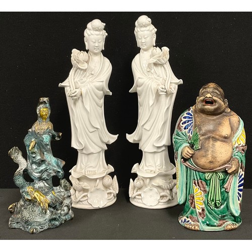 176 - A pair of Chinese blanc de chine figures, Guanyin, she stands, holding a lotus flower, 35cm high, 20... 