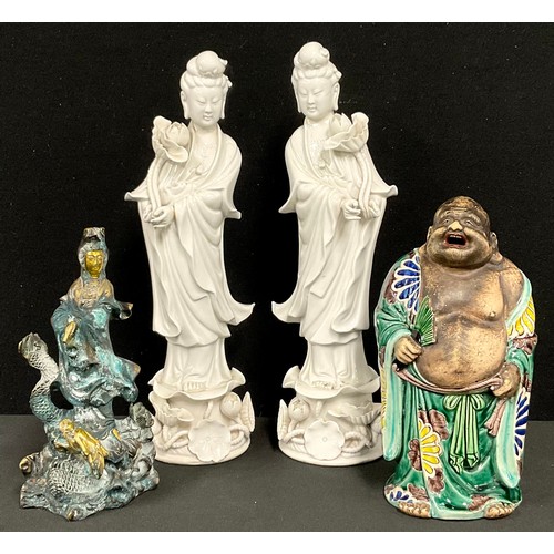 176 - A pair of Chinese blanc de chine figures, Guanyin, she stands, holding a lotus flower, 35cm high, 20... 