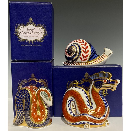 304 - A Royal Crown Derby paperweight, Dragon, gold stopper, boxed; others, Snake, gold stopper, boxed; Sn... 