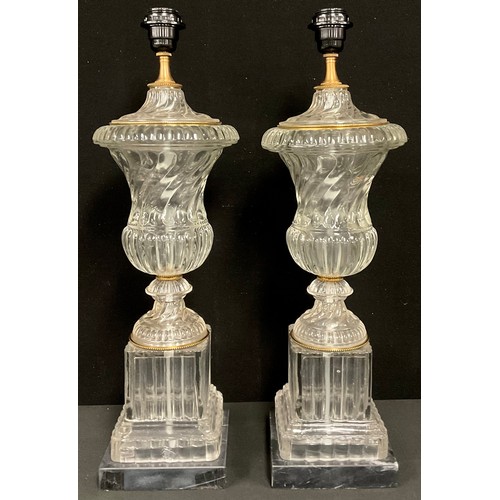 332 - A pair of gilt metal mounted glass table lamps, of urnular form, black marble bases, 60cm high