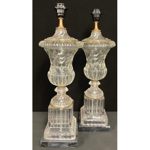 332 - A pair of gilt metal mounted glass table lamps, of urnular form, black marble bases, 60cm high