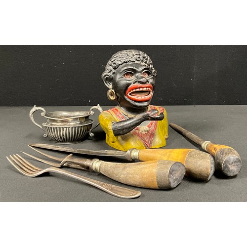 334 - A cast iron Dinah money bank;  three piece horn handled carving set, etc