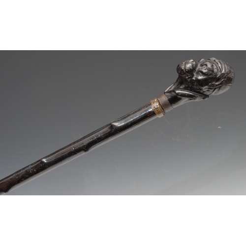 374 - An early 20th century novelty walking stick, the pommel carved as the head of a dog wearing a jockey... 