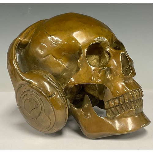 478 - A novelty patinated bronze human skull wearing headphones, 15.5cm high