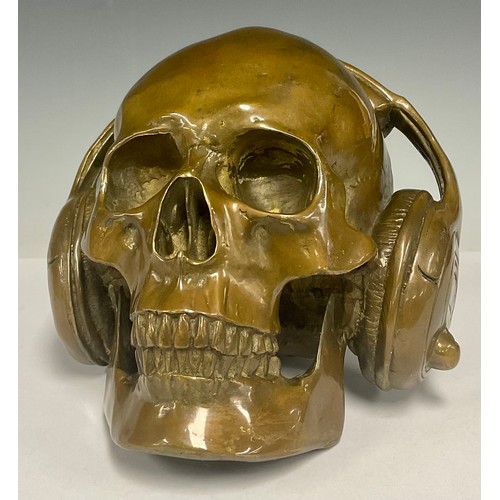 478 - A novelty patinated bronze human skull wearing headphones, 15.5cm high