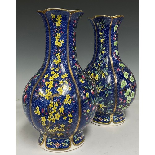 75 - A pair of contemporary Chinese porcelain vases, decorated with flowers and blossoming trees on a blu... 