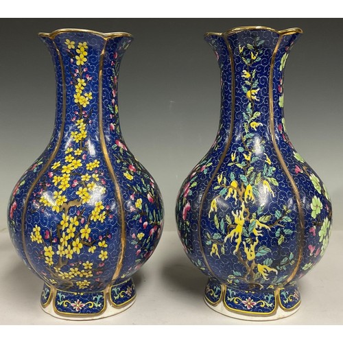 75 - A pair of contemporary Chinese porcelain vases, decorated with flowers and blossoming trees on a blu... 