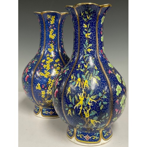 75 - A pair of contemporary Chinese porcelain vases, decorated with flowers and blossoming trees on a blu... 