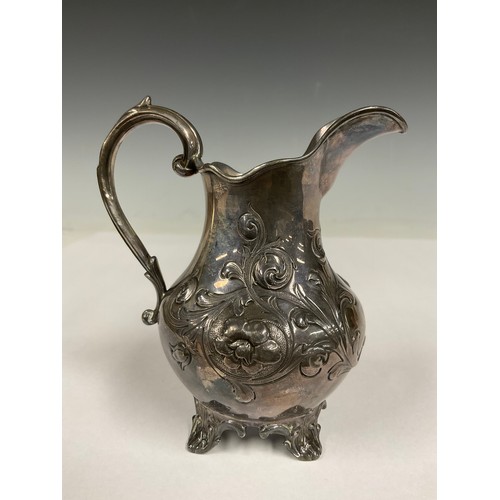 81 - A Victorian silver cream jug, chased with flowers and scrolls, four splay feet, 11.5cm high, London ... 