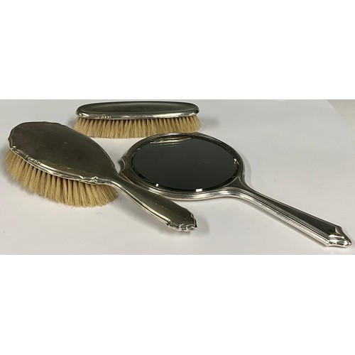 89 - A George V silver harlequin vanity set, comprising mirror and brushes, the mirror 27cm long overall