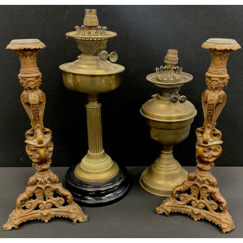 18 - A pair of cast iron Italianate Baroque gilt metal candlesticks, mask head scrolling columns, caryati... 