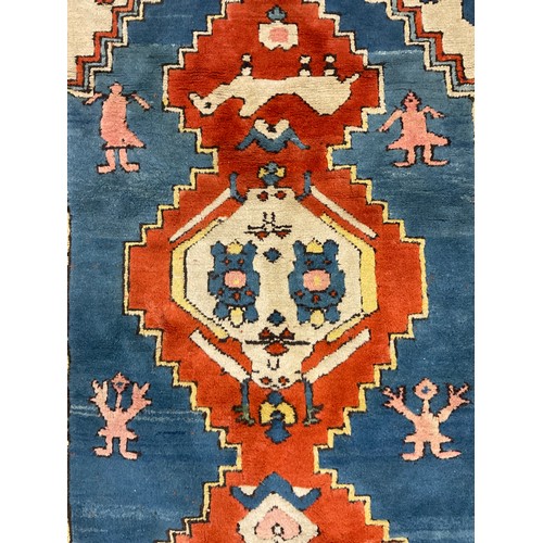 105 - A Turkish Konya rug, hand-knotted in tones of red, blue, green, and white, 247cm x 198 cm.