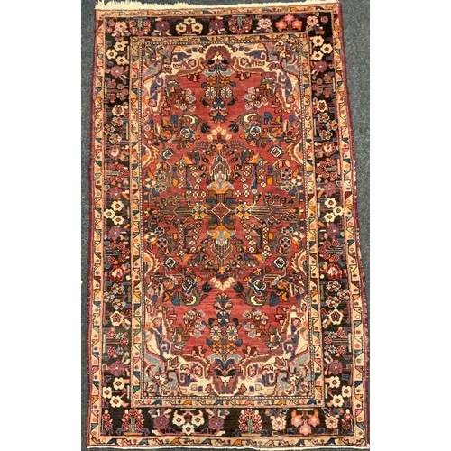 161 - A Persian Heriz type wool rug, hand-knotted with a stylised floral field, and margins, in tones of r... 