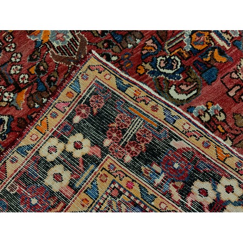 161 - A Persian Heriz type wool rug, hand-knotted with a stylised floral field, and margins, in tones of r... 