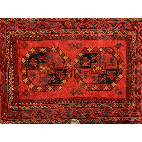 175 - An Afghan Aqcha rug, hand-knotted with a traditional geometric patterned field and radiating margins... 