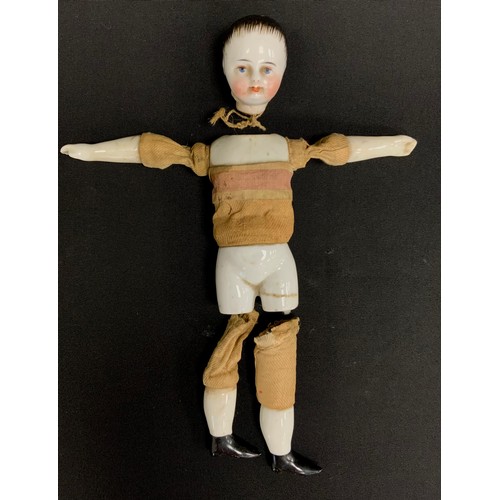 247 - A miniature continental porcelain boy doll, ceramic shoulder, limbs and lower torso, fabric and wood... 