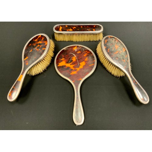 269 - A four piece silver and tortoise shell dressing set including; brushes, combs and a mirror, London 1... 