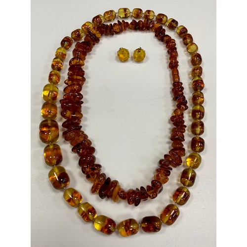 283 - A single strand freeform amber coloured bead necklace with graduated tumbled pebble beads,  another ... 