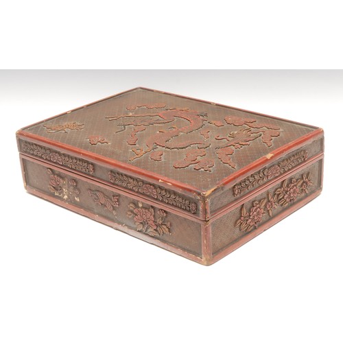 44 - A large Chinese rounded rectangular cinnabar lacquer box and cover, carved with dragon, tiger, phoen... 