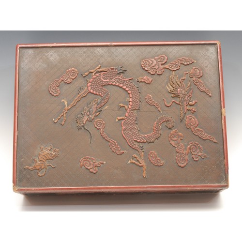 44 - A large Chinese rounded rectangular cinnabar lacquer box and cover, carved with dragon, tiger, phoen... 