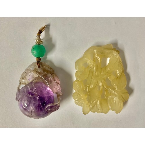 680 - A late 19th century Chinese amethyst peach pendant, carved with a bird and leafy ripe fruit, green j... 