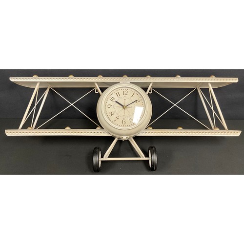 699 - A large novelty tin aeroplane wall hanging clock, 90cm wide, 36cm high