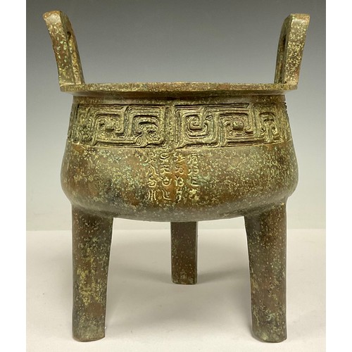 702 - A Chinese twin handled archaic style bronze coloured metal koro, 24.5cm high, 21cm wide