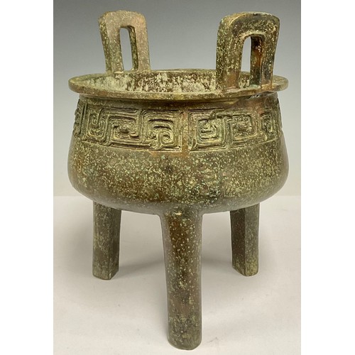 702 - A Chinese twin handled archaic style bronze coloured metal koro, 24.5cm high, 21cm wide