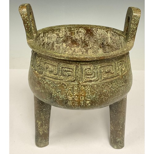 702 - A Chinese twin handled archaic style bronze coloured metal koro, 24.5cm high, 21cm wide