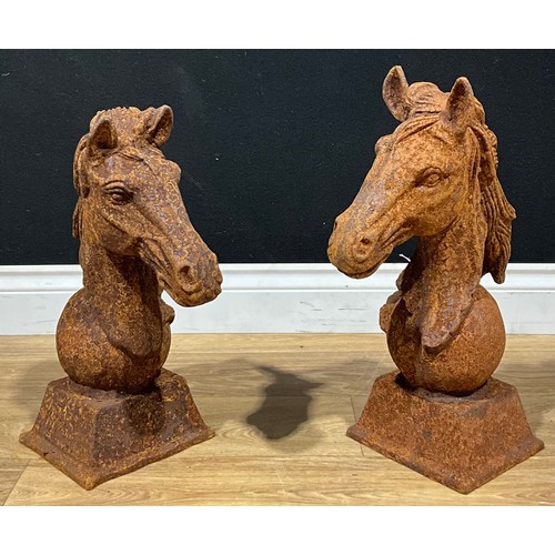 706 - A pair of cast iron gate post or wall finials in the form of horse heads, square bases, the larger 4... 