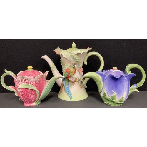 91 - A Franz porcelain Amazon Rainforest Parrot teapot and cover, 22cm high; a Franz Periwinkle teapot an... 