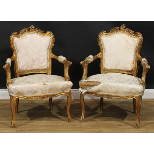 1612 - A pair of Louis XV Revival giltwood fauteuils, shaped cresting carved with scrolling leaves, stuffed... 