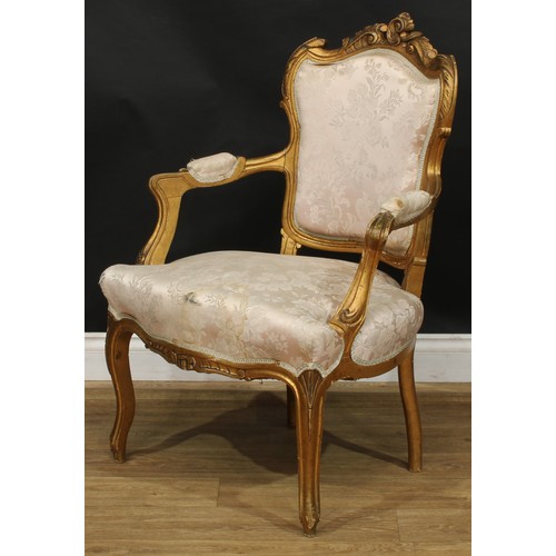 1612 - A pair of Louis XV Revival giltwood fauteuils, shaped cresting carved with scrolling leaves, stuffed... 