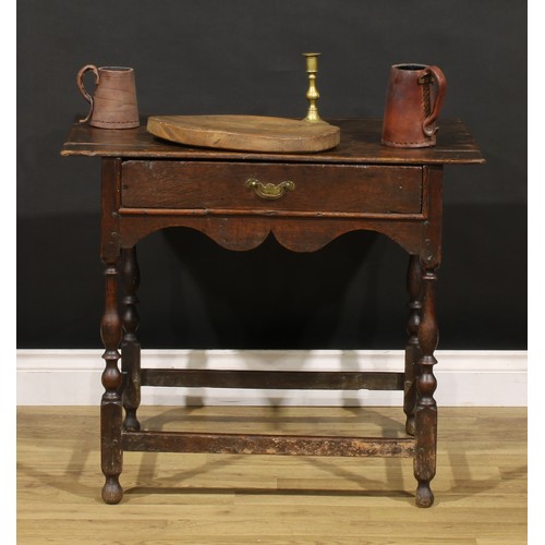 1569 - An early 18th century oak side table, oversailing rectangular top above a frieze drawer, shaped apro... 