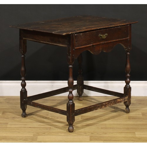 1569 - An early 18th century oak side table, oversailing rectangular top above a frieze drawer, shaped apro... 