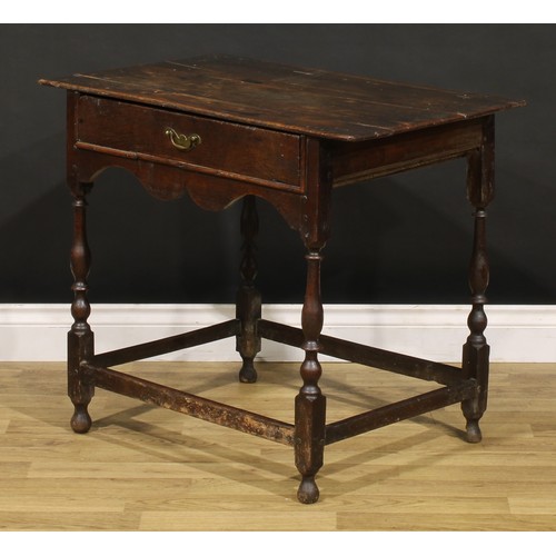 1569 - An early 18th century oak side table, oversailing rectangular top above a frieze drawer, shaped apro... 