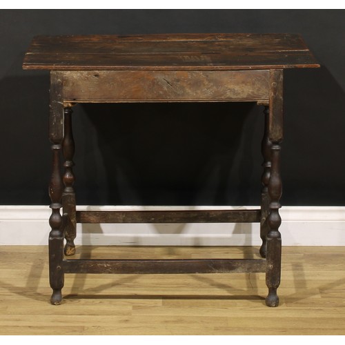 1569 - An early 18th century oak side table, oversailing rectangular top above a frieze drawer, shaped apro... 