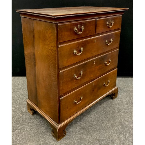 1776 - A George III oak chest of drawers, the over-sailing top with swept moulded edge, above two short, an... 