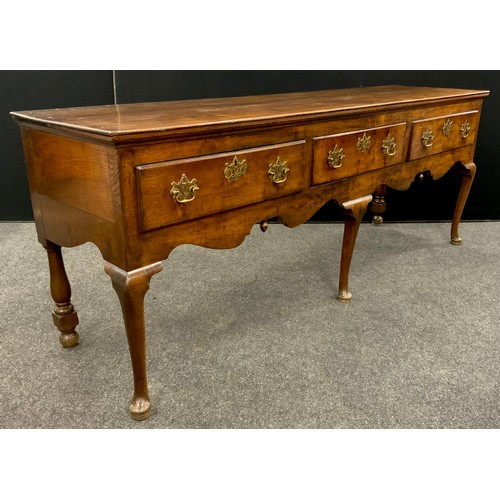 1781 - A George III oak low dresser , the slightly over-sailing quarter-sawn oak top, above three short dra... 