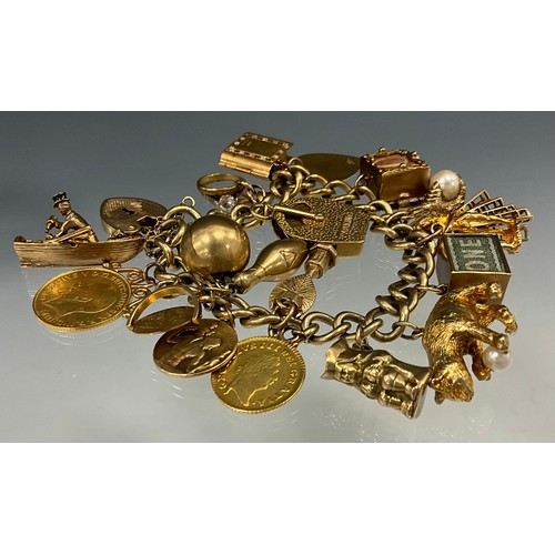 535 - A 9ct gold charm bracelet suspending nineteen charms including George III third of a guinea, 1800, a... 